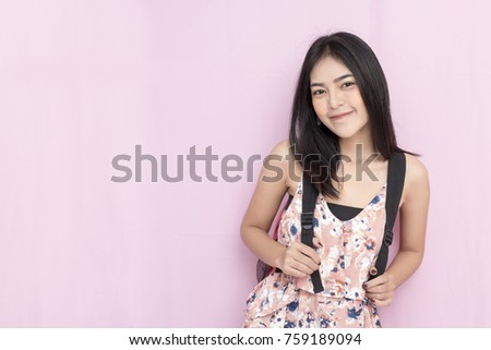 Portrait of happy woman with bag smiling on pink wall background with free copy space. Travel or education concept. Picture for add text message. Backdrop for design art work.