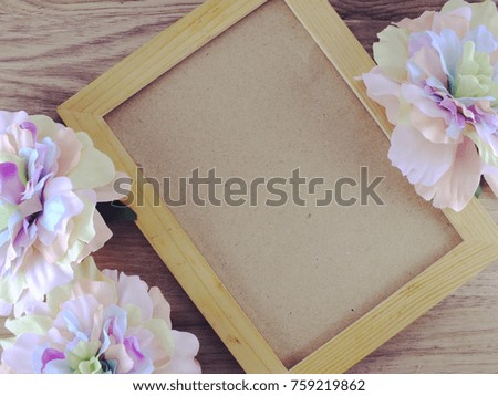 wooden picture frame on wooden background with flowers