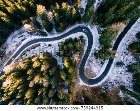 Aerial view of snowy forest with a road. Captured from above with a drone. Dolomites - Italy Royalty-Free Stock Photo #759244915