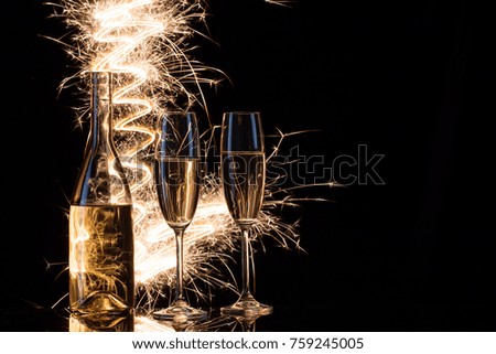 Celebration of champagne in the sparks of Bengal lights. Black background. The concept of the celebration of the wedding and the new year. Copy space.