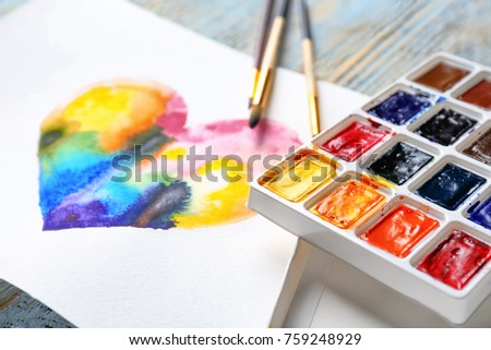 Painting of rainbow heart on table, closeup