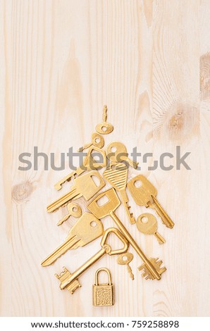 Luxury christmas tree of gold retro keys on soft beige wooden background, copy space. Top view, vertical.