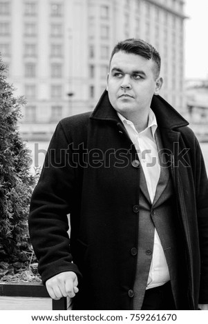 Young plus size man relaxing and enjoying the view city, plump people concept, one in big city life. Image of overweight businessman at downtown