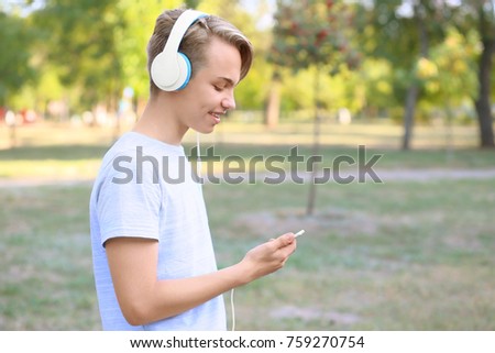 Teenager boy with headphones listening to music outdoors