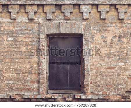 An old brick wall with a small window. Texture of an old brick wall.