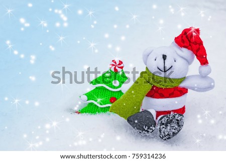 Christmas and new year background. Toy Christmas tree and white dog in a red Christmas hat with ornaments on natural snow.