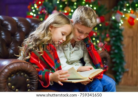 Children reading an interest book sitting on the bed against the