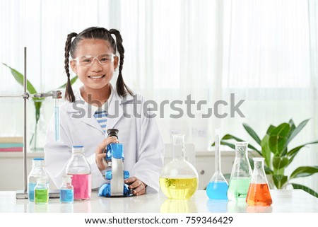 Happy Vietnamese schoolgirl having chemistry class