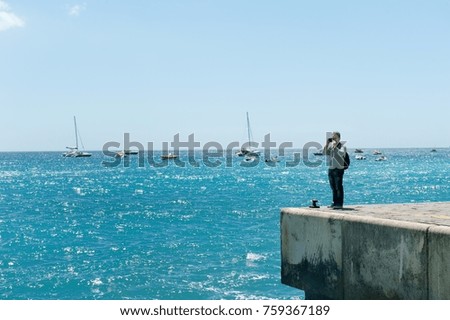 A tourist with backpack taking pictures near blue sea of Positano, Amalfi coast, Italy, Europe