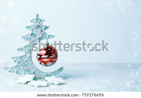 Close up of decorative christmas tree and red christmas glass ball. Cold colors, snow. copy space, place for your text.