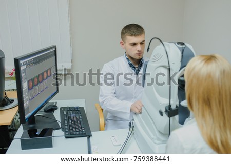 Young beautiful doctor/eye specialist/optometrist in an ophthalmologic clinic dooing a patient a Tomography in Optical Coherence (OCT) Royalty-Free Stock Photo #759388441