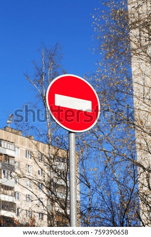 Ban road sign in city against blue sky background
