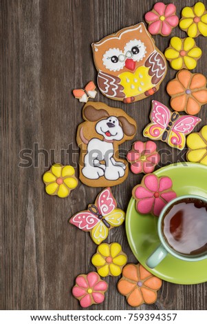 Gingerbread in the shape of flower, butterfly, an owl, dog on dark wooden surface.
