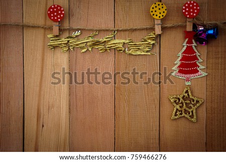 Christmas set hang on wooden background.It have rope,reindeer,carriage,bell,christmas tree,star and paper clip.