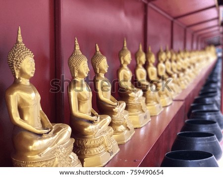 Row of golden Buddha and red background.