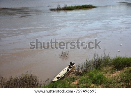 A wooden boat parking on the riverside