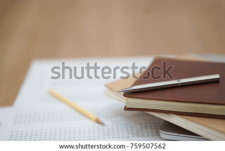 close up soft focus on Clutch-type pencil lay on notebook and exam sheet test paper:blur picture concept.
