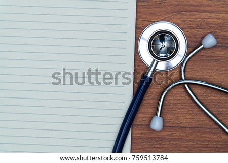Stethoscope and notebook on bright wood table top view with copy space, health and concept.