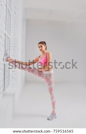 Fitness woman doing stretching workout. Full length shot of young woman on white background. Stretching and motivation