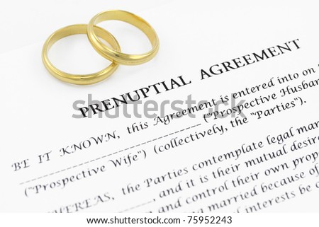 Form of prenuptial agreement with a pair of wedding rings Royalty-Free Stock Photo #75952243