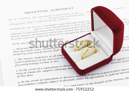 Form of prenuptial agreement with a pair of wedding rings Royalty-Free Stock Photo #75952252