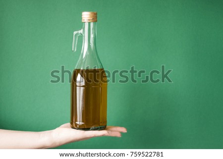 Hand with bottle of cooking oil isolated on a colored background