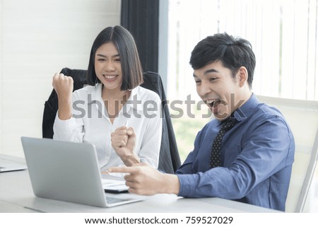 Asian Business People working together. Man and Woman looking to laptop with happy emotion. People with Business Success Concept.