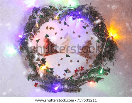 Christmas or New year festive background. Greeting card composition with green wreath, colorful garland lights, glitters and fir trees made of bread. Holidays concept.