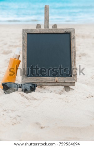 Chalk board with sunscreen cream in the sand on the beach tropic exotic background