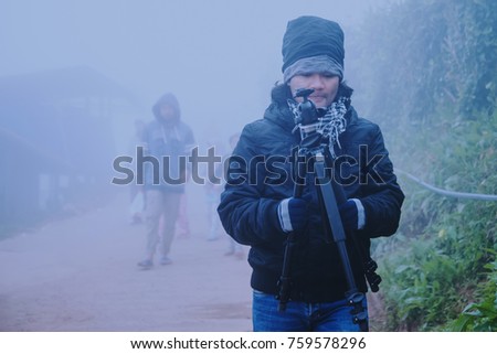 Asian man photographer relax in the holiday. Happy to travel in the holiday. During the foggy winter