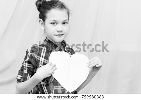 Smiling child holding a paper heart.