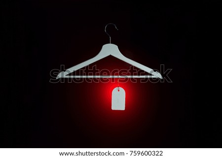sale tag and coat hanger on dark background.End of Year sale concept.