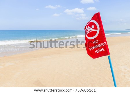 red flag warning no swimming sign on the tropical beach with blue sky background