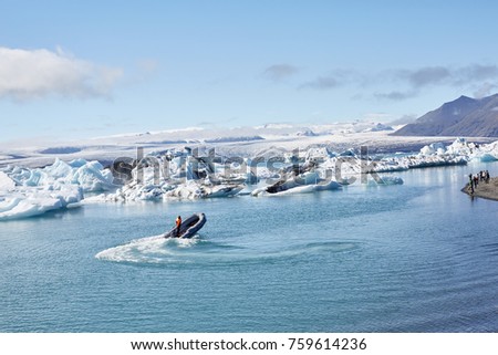 Beatufil vibrant picture of icelandic glacier and glacier lagoon with water and ice in cold blue tones, Iceland, Glacier Bay. in the lagoon a motor boat is floating