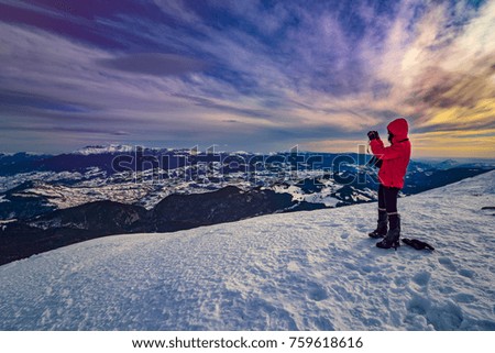 young woman taking pictures during winter time at sunset