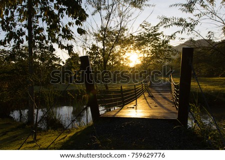 Silhouette of the wooden bridge across the river with The morning light shines.selective focus.