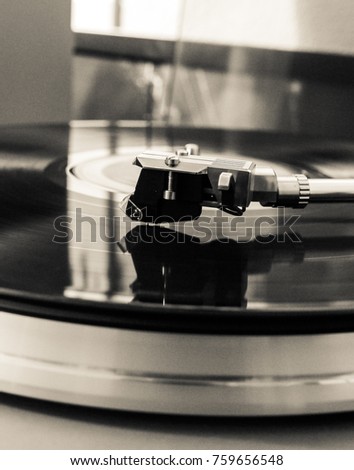 Close up image of a needle on a vinyl record being played on a turntable. Taken in Black and White