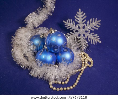 set blue beautiful glass New Year's balls, brilliant tinsel,  and a pearl beads on a blue background - New Year's composition, a card