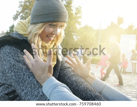 cute young woman meeting with boyfriend outdoors, excited girl jumps into hands of the guy