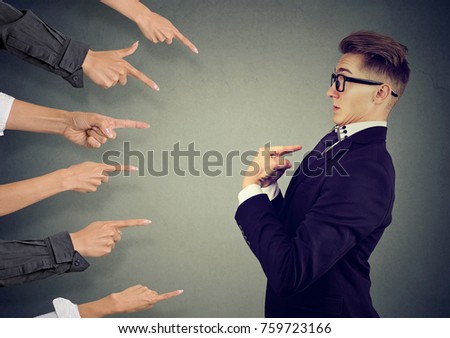 Blaming you. Anxious man judged by different people pointing fingers at him. Negative human emotions feeling Royalty-Free Stock Photo #759723166