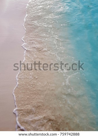 Waves breaking on white sandy beach