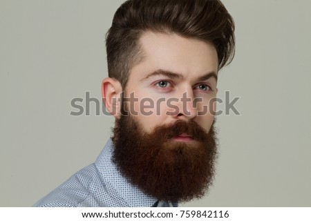 A young guy with a beard . 
Guy after a hairdresser with a well-groomed beard and a beautiful hairdo . Stylish young guy .  Royalty-Free Stock Photo #759842116