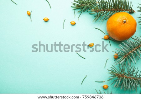 Ripe mandarin, sea buckthorn and needles, Christmas background.