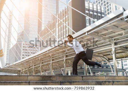 Young Asian Businessman Running with haste,Motion blurred and warm tone filter effect. Business Competition Concepts.