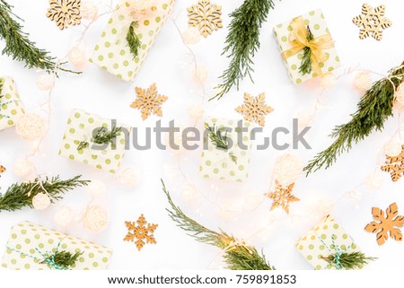 Christmas or new year texture. Christmas decorations in gold colors, boxes and green branches, snowflakes on white background. Holiday and celebration concept. Top view. Flat lay