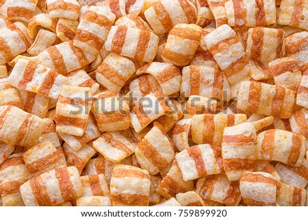 Food background. Chips in the form of bacon. Oblong potato chips in the strip. Abstract background. Studio light.