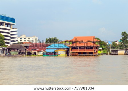 Picture of the houses along the Chao Phraya River when flood tide a gainst a clouds and blue sky.Chao Phraya River lifestyle.