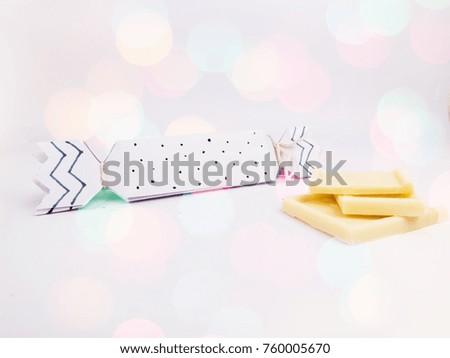 Christmas Decoration with black and white cracker chocolate box and white chocolate with colorful bokeh and snow for holidays best background image for Holiday invitation and banners