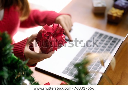 Woman hand holding red gift box about shopping online. christmas event concept.