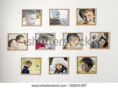 white wall with photos of the family in wooden photo frames